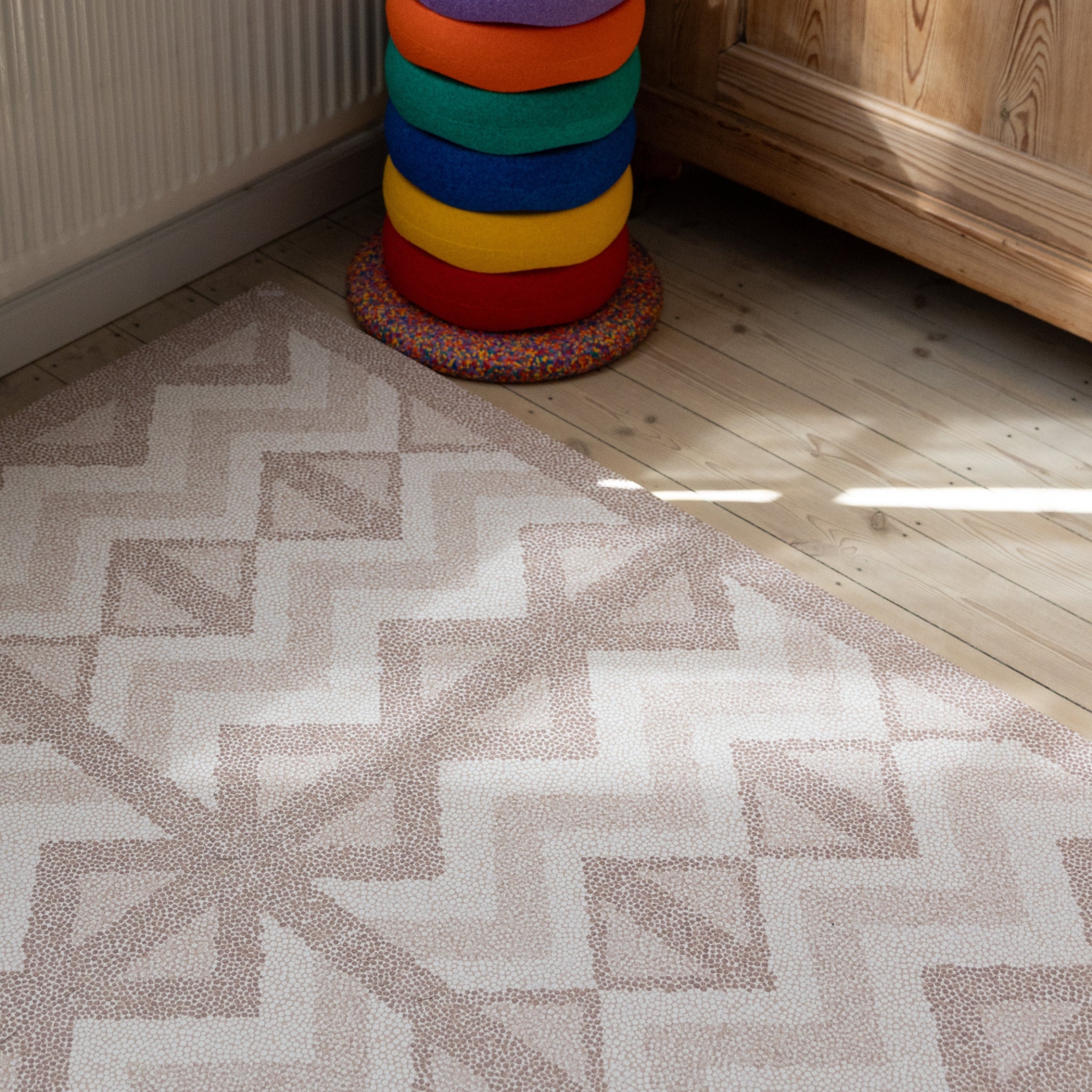 Close-up van speelmat baby foam Kilim Soft Clay van Eeveve op een houten vloer, met zichtbaar zacht textuurdetail